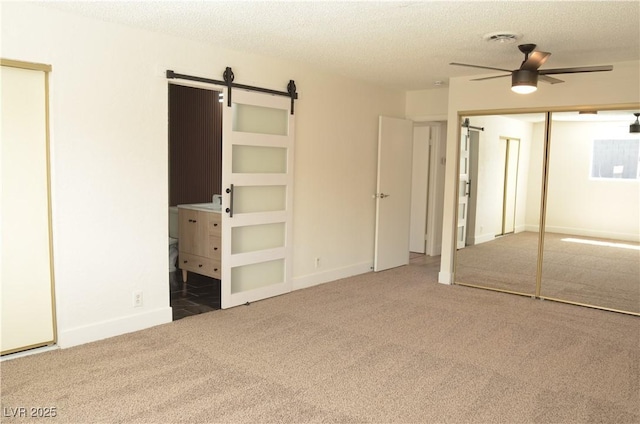 4277 Rimcrest Rd, Las Vegas, NV 89121 - unfurnished bedroom with carpet flooring, a barn door, and a textured ceiling