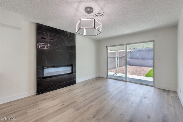 4277 Rimcrest Rd, Las Vegas, NV 89121 - unfurnished room with a textured ceiling, a fireplace, and wood finished floors