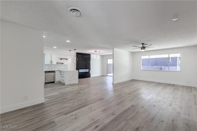 4277 Rimcrest Rd, Las Vegas, NV 89121 - unfurnished living room with a ceiling fan, a textured ceiling, light wood-style floors, and recessed lighting