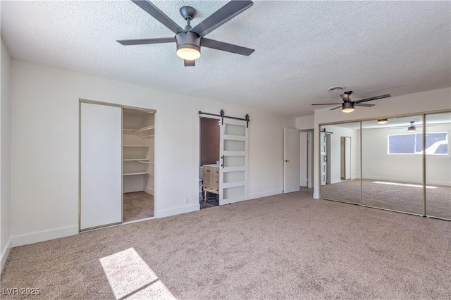 4277 Rimcrest Rd, Las Vegas, NV 89121 - unfurnished bedroom featuring a textured ceiling, carpet, a barn door, and a ceiling fan