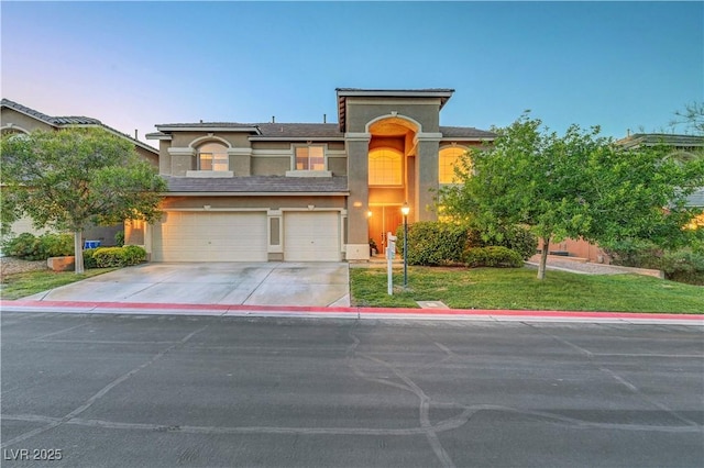 8812 Glenistar Gate Ave, Las Vegas, NV 89143 - view of front of home featuring stucco siding, driveway, an attached garage, and a front lawn