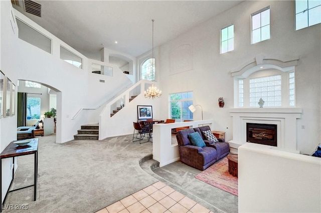 8812 Glenistar Gate Ave, Las Vegas, NV 89143 - carpeted living area with a towering ceiling, stairway, healthy amount of natural light, a chandelier, and recessed lighting