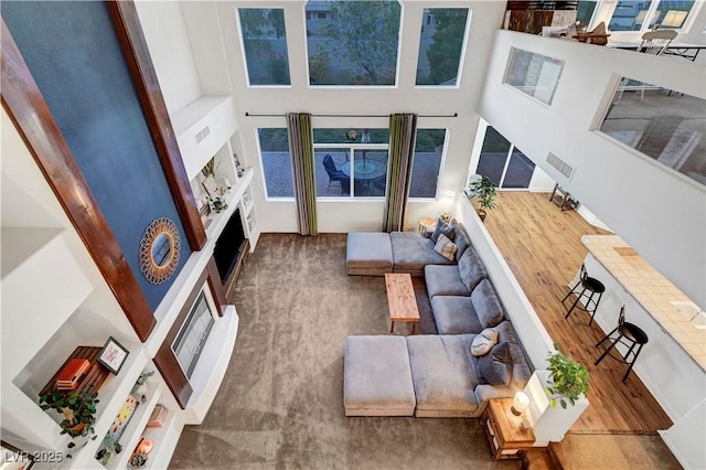 8812 Glenistar Gate Ave, Las Vegas, NV 89143 - living area with wood finished floors, a towering ceiling, and a fireplace