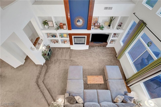 8812 Glenistar Gate Ave, Las Vegas, NV 89143 - carpeted living area with built in shelves and a fireplace