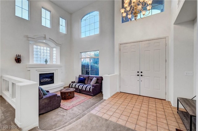 8812 Glenistar Gate Ave, Las Vegas, NV 89143 - foyer with a towering ceiling, a chandelier, healthy amount of natural light, and a glass covered fireplace