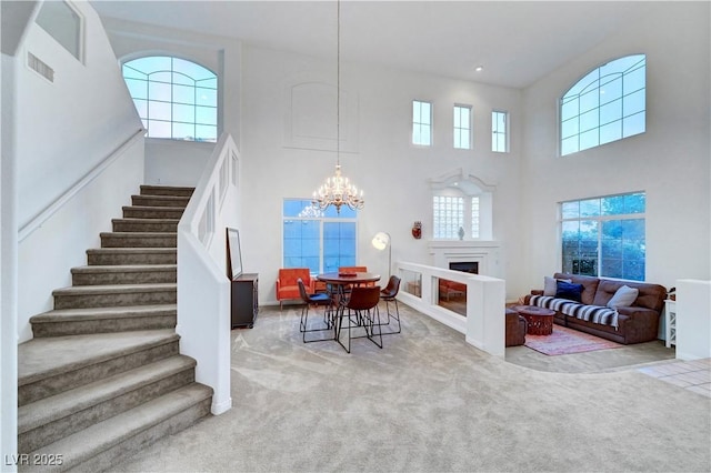 8812 Glenistar Gate Ave, Las Vegas, NV 89143 - dining room with a high ceiling, stairs, plenty of natural light, carpet flooring, and a chandelier