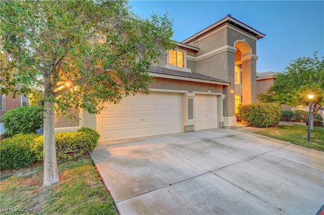 8812 Glenistar Gate Ave, Las Vegas, NV 89143 - view of front of house featuring a garage, stucco siding, and driveway