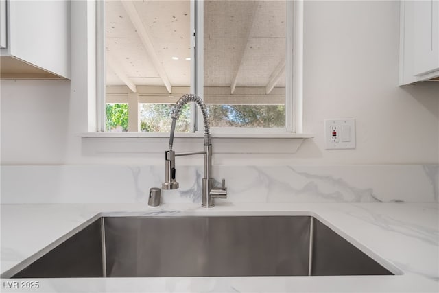 1700 Sweeney Ave, Las Vegas, NV 89104 - kitchen view of white cabinetry, light stone countertops, and backsplash