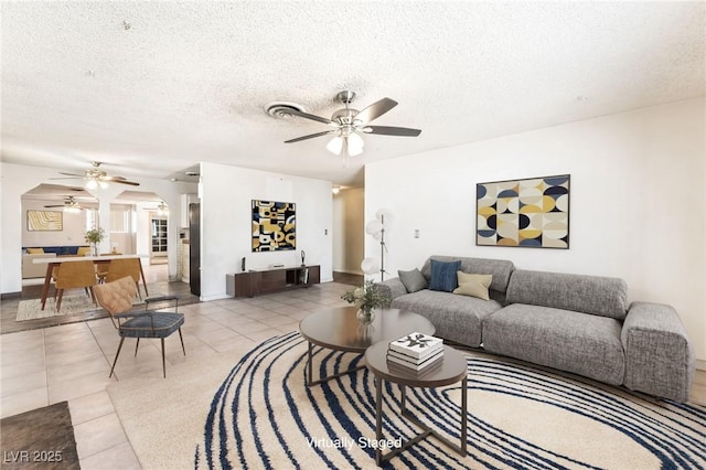 5809 Pebble Beach Blvd, Las Vegas, NV 89108 - living room featuring ceiling fan, arched walkways, light tile patterned floors, and a textured ceiling