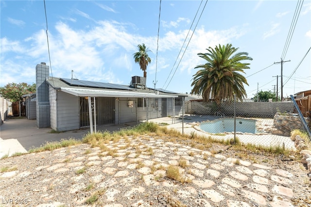 5809 Pebble Beach Blvd, Las Vegas, NV 89108 - back of property featuring roof mounted solar panels, a fenced backyard, a patio area, and a chimney