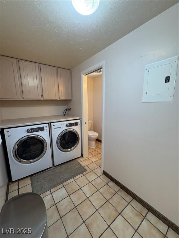 1133 Bell Ave, Ely, NV 89301 - laundry area with electric panel, washer and dryer, cabinet space, a textured ceiling, and light tile patterned floors