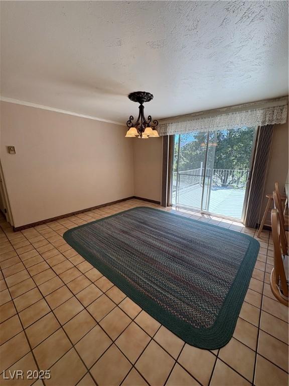 1133 Bell Ave, Ely, NV 89301 - empty room featuring light tile patterned flooring, a chandelier, ornamental molding, and a textured ceiling