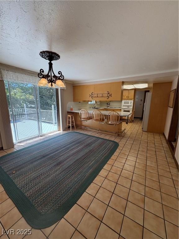 1133 Bell Ave, Ely, NV 89301 - living room featuring a chandelier, light tile patterned flooring, and a textured ceiling