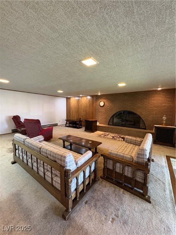 1133 Bell Ave, Ely, NV 89301 - living room with light colored carpet, a brick fireplace, a textured ceiling, and a baseboard radiator