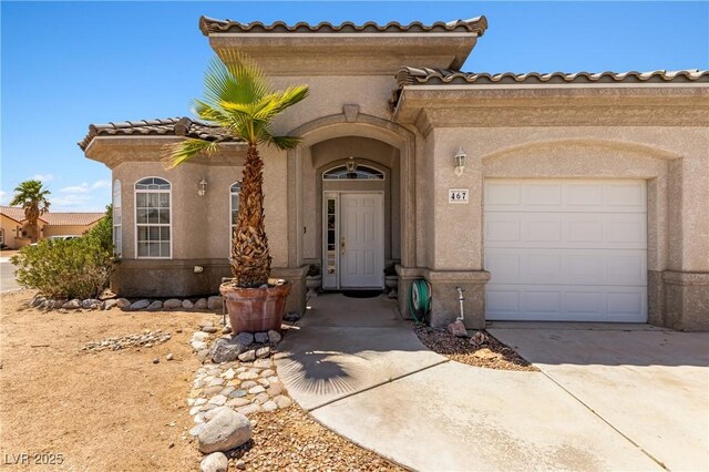 467 Muddy Peak Ct, Overton, NV 89040 - property entrance with an attached garage, stucco siding, concrete driveway, and a tiled roof