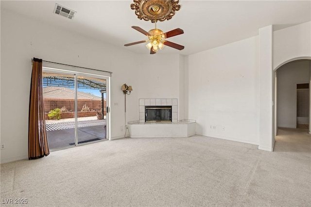 467 Muddy Peak Ct, Overton, NV 89040 - unfurnished living room featuring arched walkways, carpet floors, a tiled fireplace, and a ceiling fan
