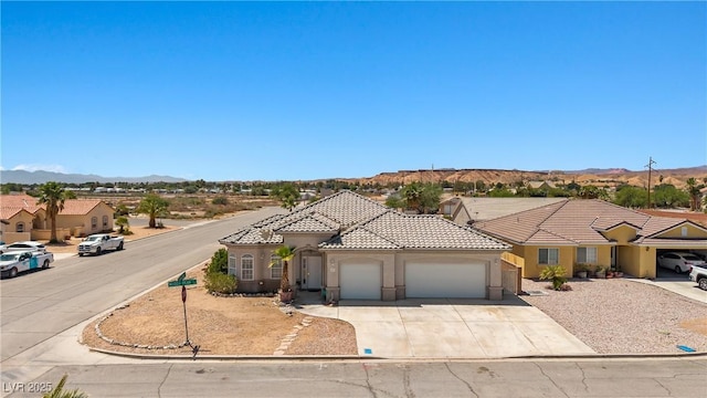 467 Muddy Peak Ct, Overton, NV 89040 - mediterranean / spanish house featuring a garage, a mountain view, stucco siding, a tiled roof, and driveway