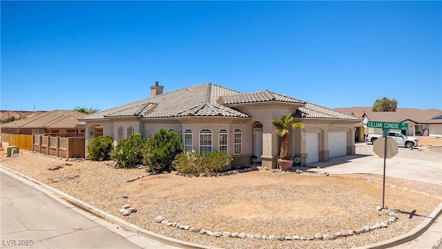 467 Muddy Peak Ct, Overton, NV 89040 - mediterranean / spanish-style home with concrete driveway, a garage, stucco siding, a tile roof, and a chimney