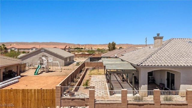 467 Muddy Peak Ct, Overton, NV 89040 - rear view of property with a playground, a tiled roof, a fenced backyard, stucco siding, and a chimney
