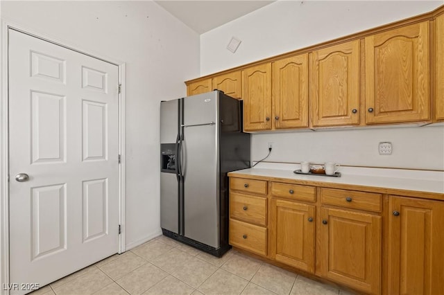 467 Muddy Peak Ct, Overton, NV 89040 - kitchen featuring fridge with ice dispenser, light countertops, light tile patterned floors, and brown cabinets