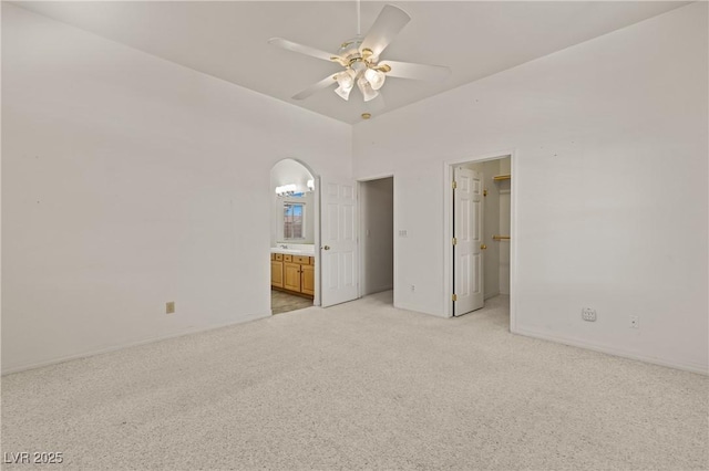 467 Muddy Peak Ct, Overton, NV 89040 - unfurnished bedroom featuring light colored carpet, connected bathroom, a ceiling fan, and a walk in closet