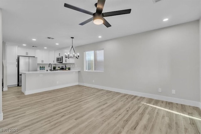 10373 Midnight Iris St, Las Vegas, NV 89183 - unfurnished living room featuring recessed lighting, light wood-style floors, ceiling fan, and a chandelier