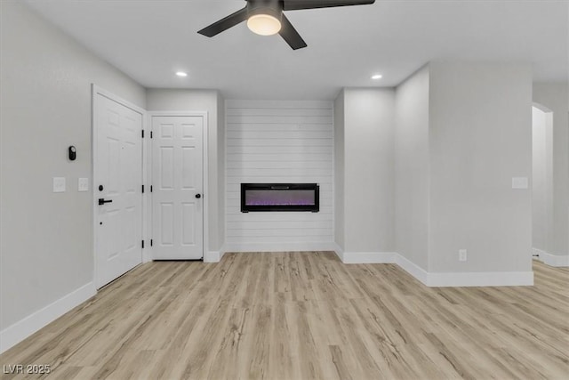 10373 Midnight Iris St, Las Vegas, NV 89183 - unfurnished living room featuring a fireplace, ceiling fan, wood finished floors, and recessed lighting