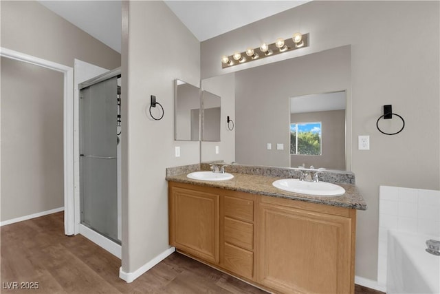 1553 Ivygate Ave, Las Vegas, NV 89183 - full bath featuring wood finished floors, double vanity, a shower stall, and a garden tub