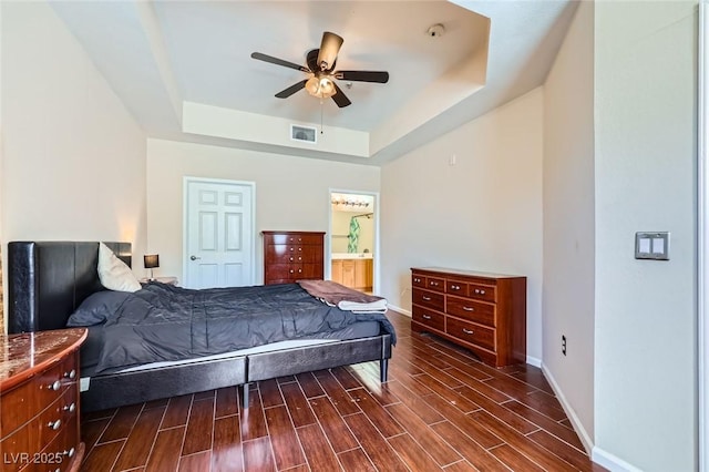 43 E Agate Ave Unit 302, Las Vegas, NV 89123 - bedroom with a tray ceiling, dark wood finished floors, connected bathroom, and a ceiling fan