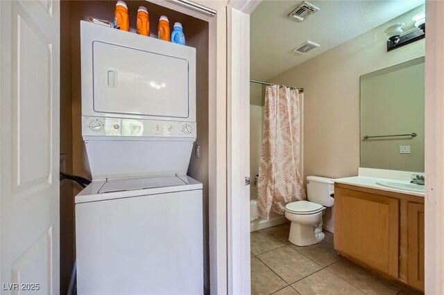 43 E Agate Ave Unit 302, Las Vegas, NV 89123 - bathroom with stacked washing machine and dryer, vanity, tile patterned flooring, and shower / bathtub combination with curtain