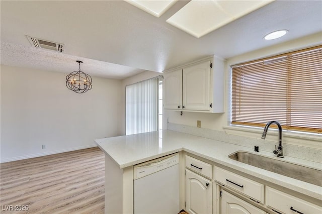 1201 Bourbon St, Pahrump, NV 89048 - kitchen with dishwasher, a peninsula, light wood finished floors, light countertops, and a chandelier