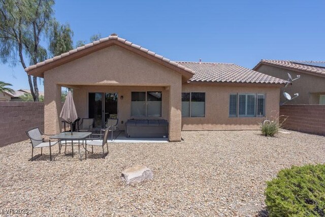 5935 Saddle Horse Ave, Las Vegas, NV 89122 - rear view of property with a tiled roof, stucco siding, and a patio