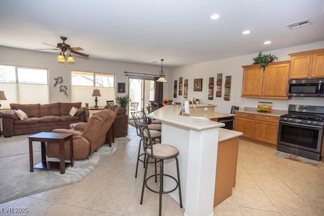 5935 Saddle Horse Ave, Las Vegas, NV 89122 - kitchen with stainless steel appliances, open floor plan, a kitchen breakfast bar, light countertops, and recessed lighting