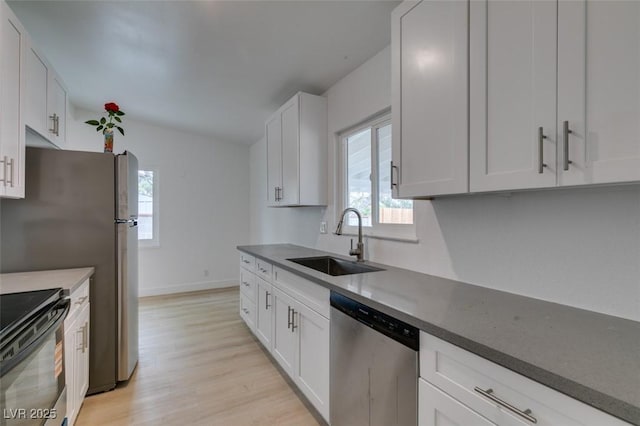 709 N 22nd St, Las Vegas, NV 89101 - kitchen with appliances with stainless steel finishes, healthy amount of natural light, light wood-style floors, and white cabinets