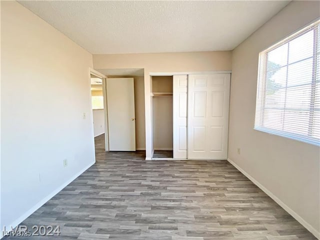 2705 Jennydiane Dr, Las Vegas, NV 89121 - unfurnished bedroom featuring wood finished floors, a closet, and a textured ceiling