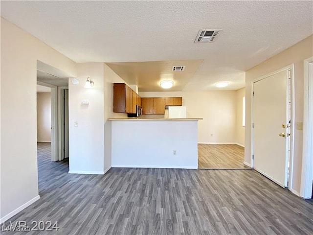 2705 Jennydiane Dr, Las Vegas, NV 89121 - kitchen with wood finished floors, fridge, brown cabinetry, and open floor plan
