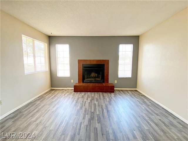 2705 Jennydiane Dr, Las Vegas, NV 89121 - unfurnished living room featuring wood finished floors, a fireplace with raised hearth, and a textured ceiling