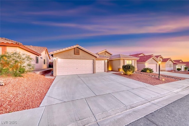 1643 Silver Slipper Ave, Henderson, NV 89002 - mediterranean / spanish home featuring an attached garage, stucco siding, concrete driveway, and a tile roof