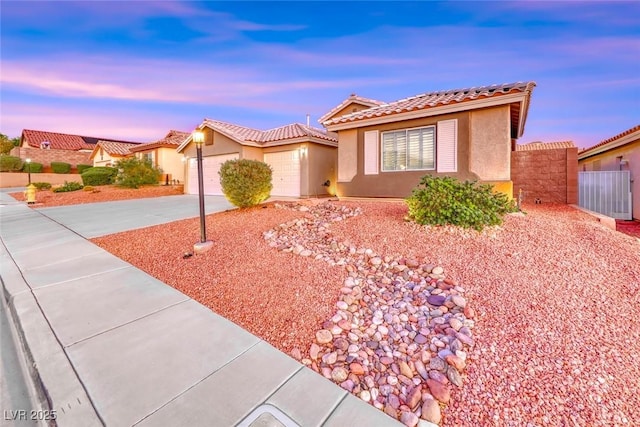 1643 Silver Slipper Ave, Henderson, NV 89002 - view of front of house with concrete driveway, an attached garage, a tile roof, and stucco siding