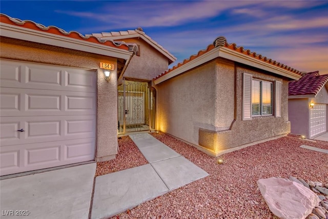 1643 Silver Slipper Ave, Henderson, NV 89002 - mediterranean / spanish-style house featuring stucco siding, a tiled roof, a gate, and a garage