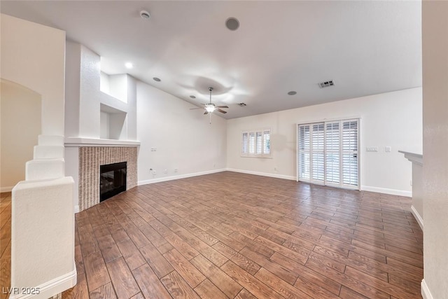 1643 Silver Slipper Ave, Henderson, NV 89002 - unfurnished living room featuring a tiled fireplace, a ceiling fan, wood finished floors, and vaulted ceiling