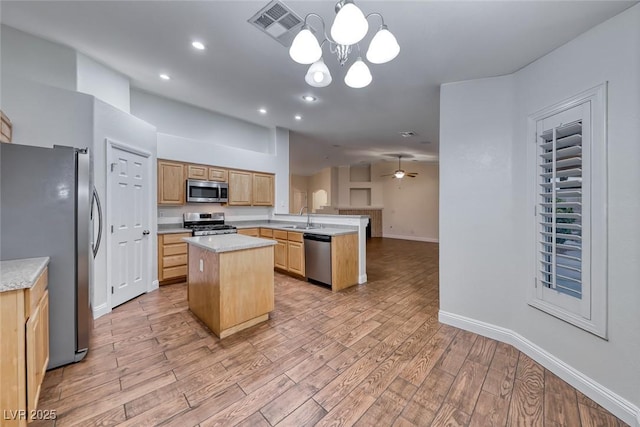 1643 Silver Slipper Ave, Henderson, NV 89002 - kitchen featuring stainless steel appliances, a peninsula, light countertops, light wood-style flooring, and vaulted ceiling