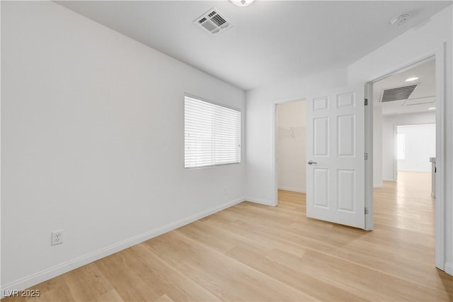 7775 Tyrell Peaks St, Las Vegas, NV 89139 - unfurnished bedroom with light wood-style flooring, a spacious closet, and a closet