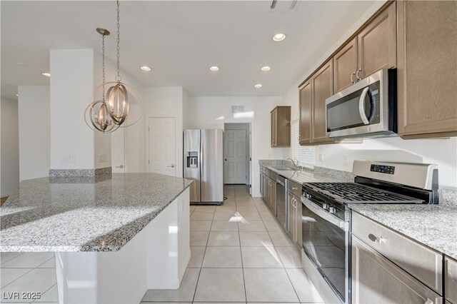 7775 Tyrell Peaks St, Las Vegas, NV 89139 - kitchen featuring appliances with stainless steel finishes, a chandelier, light stone countertops, recessed lighting, and hanging light fixtures