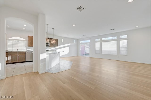 7775 Tyrell Peaks St, Las Vegas, NV 89139 - unfurnished living room with light wood-type flooring, arched walkways, and recessed lighting