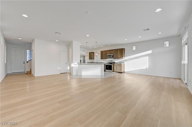 7775 Tyrell Peaks St, Las Vegas, NV 89139 - unfurnished living room with light wood-style flooring and recessed lighting