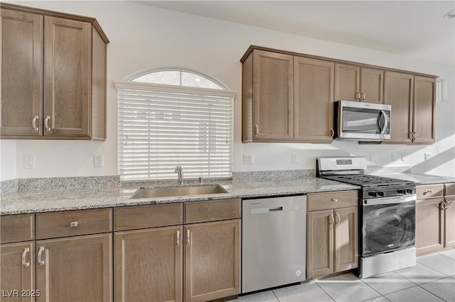 7775 Tyrell Peaks St, Las Vegas, NV 89139 - kitchen with appliances with stainless steel finishes, light stone countertops, and light tile patterned flooring