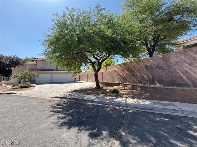 6293 Pavestone Ln, Las Vegas, NV 89142 - view of front facade featuring a tile roof, driveway, a garage, and stucco siding