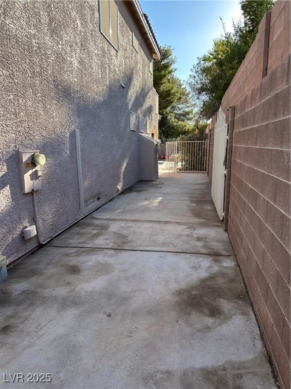 6293 Pavestone Ln, Las Vegas, NV 89142 - view of home's exterior with stucco siding and a patio area