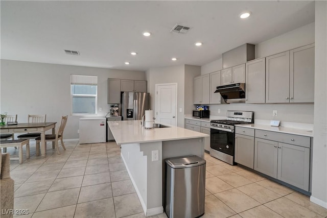 10630 Adobe Ranch St, Las Vegas, NV 89141 - kitchen featuring appliances with stainless steel finishes, under cabinet range hood, gray cabinetry, light tile patterned floors, and light countertops